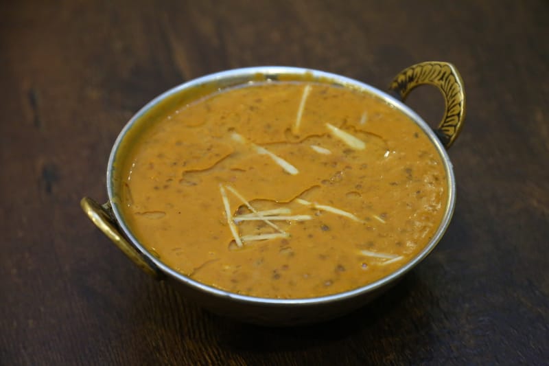 Dal makhani simmered in a brass-handled kadai