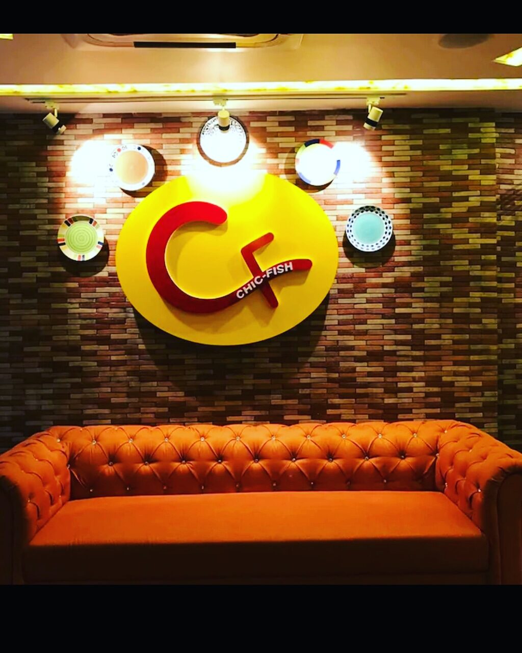 The Chic Fish emblem on the brick feature wall above lounge seating